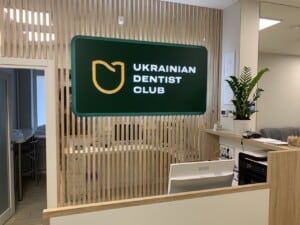 Інтерʼєрна вивіска з підсвіткою Ukrainian Dentist Club на ресепшні